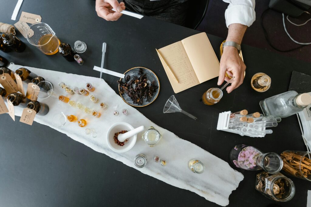 pexels-photo-8450125-8450125-2 Overhead view of artisan crafting perfume using natural ingredients at a worktable.