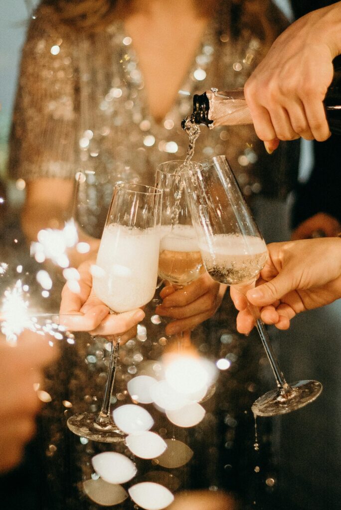 pexels-photo-3171770-3171770 People toasting with champagne glasses amidst sparklers at a festive party.